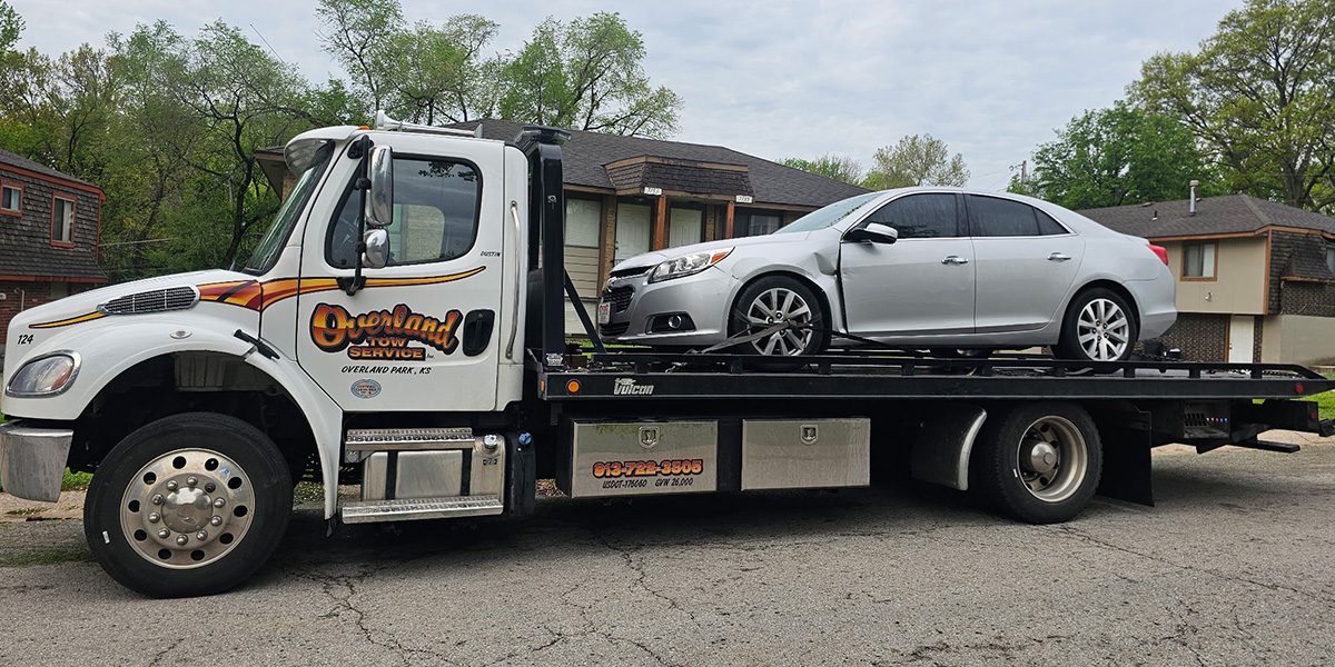 Roeland park tow truck driver hauling a wrecked car